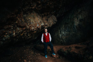 brendan standing in dark rocky cave
